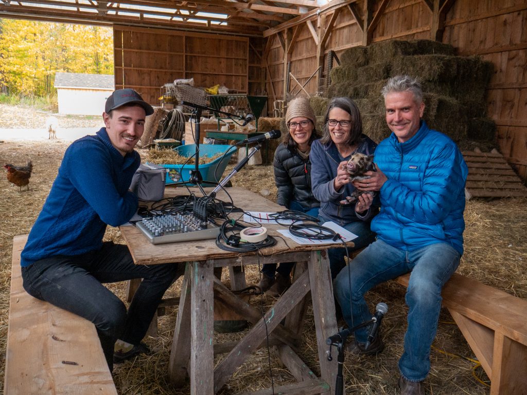 Podcast guests sitting around a table inside a barn